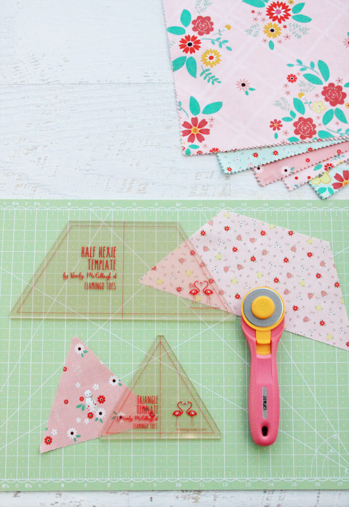 New Quilting Templates on the Way! by popular Tennessee quilting blog, Flamingo Toes: image of the half hexie and triangle template on a green rotary board next to a rotary cutter.